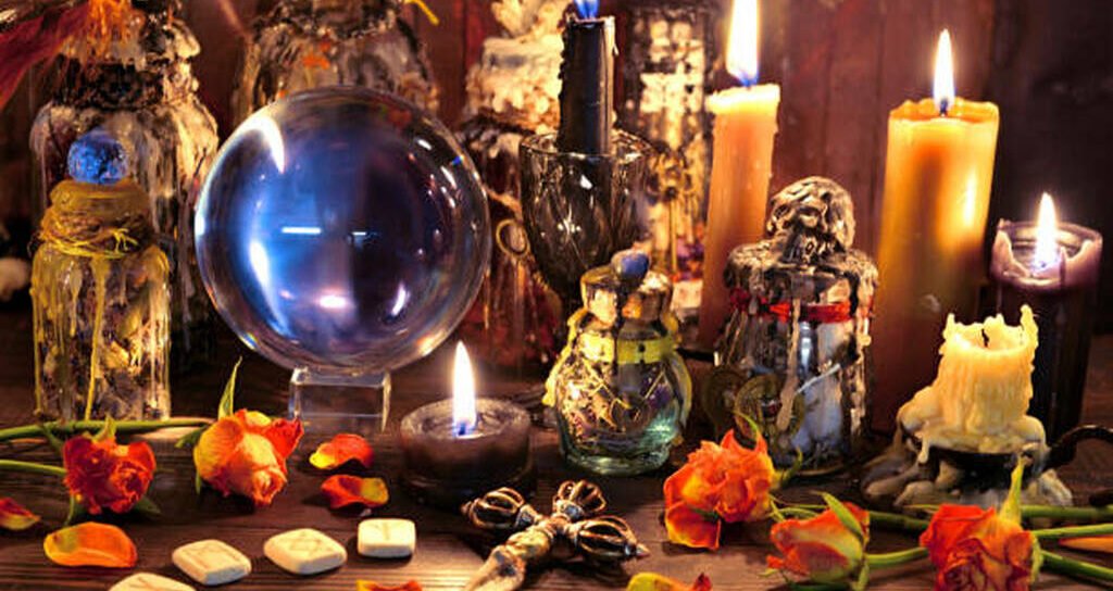Crystal ball with runes, black candle and witch magic bottle. Wicca, esoteric, Halloween and occult background with vintage magic objects for mystic rituals